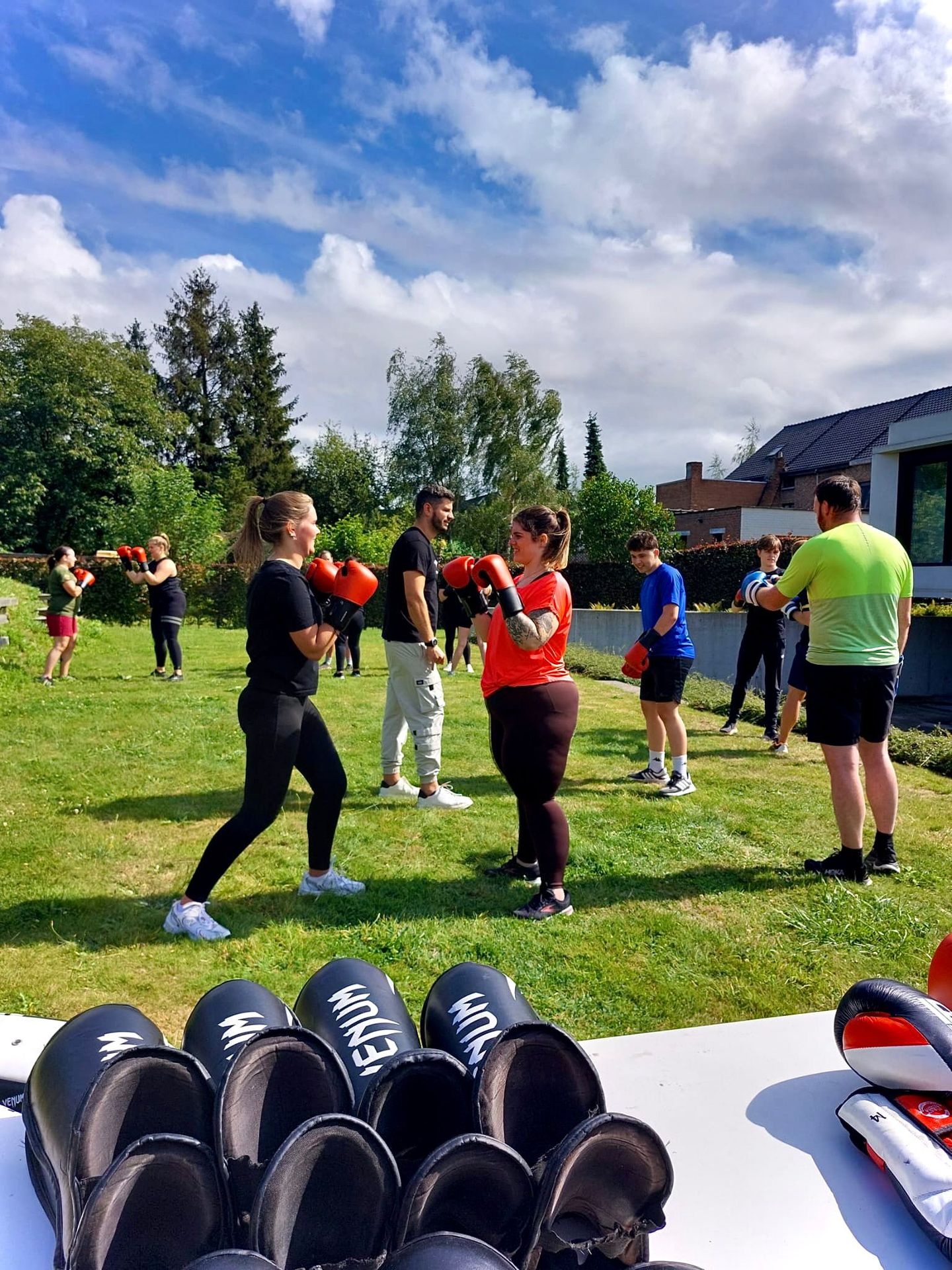 Groep deelnemers traint samen buiten in het gras tijdens een groepsles van SHOBI Move en Relax