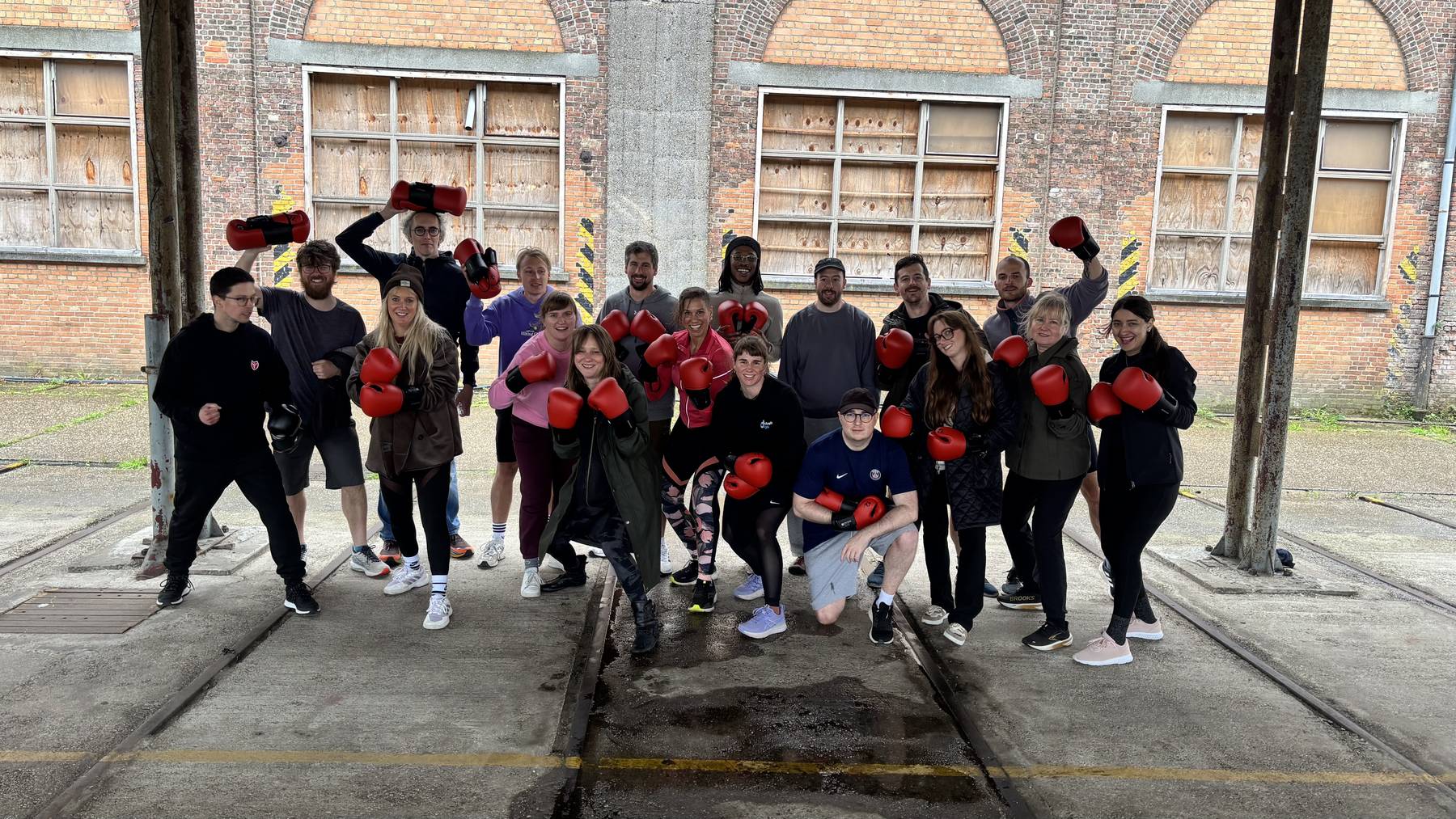 Groepsfoto van het team van Baldwin BV met rode bokshandschoenen na hun teambuilding