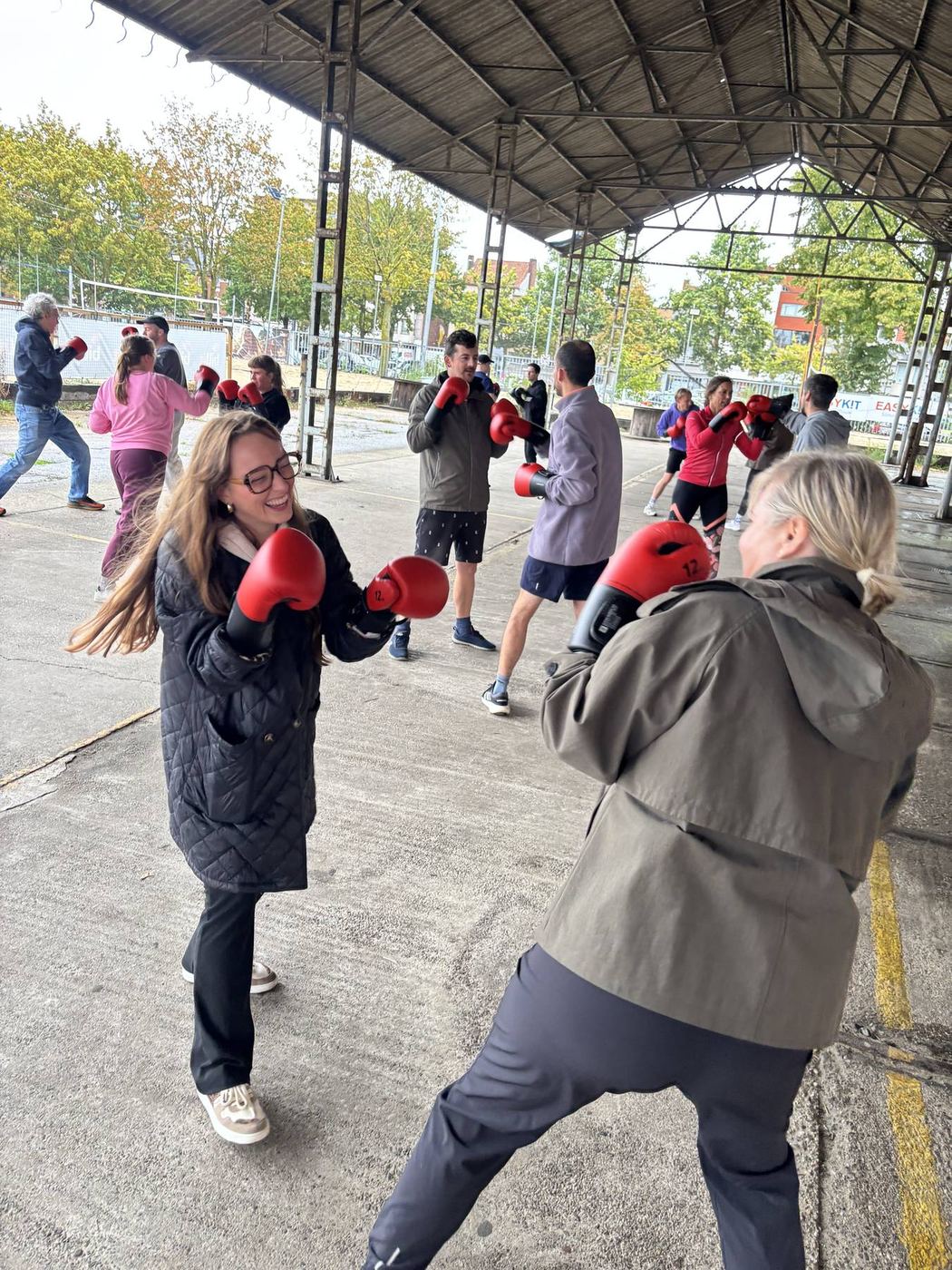 Twee vrouwen lachen terwijl ze samen boksen onder het afdak