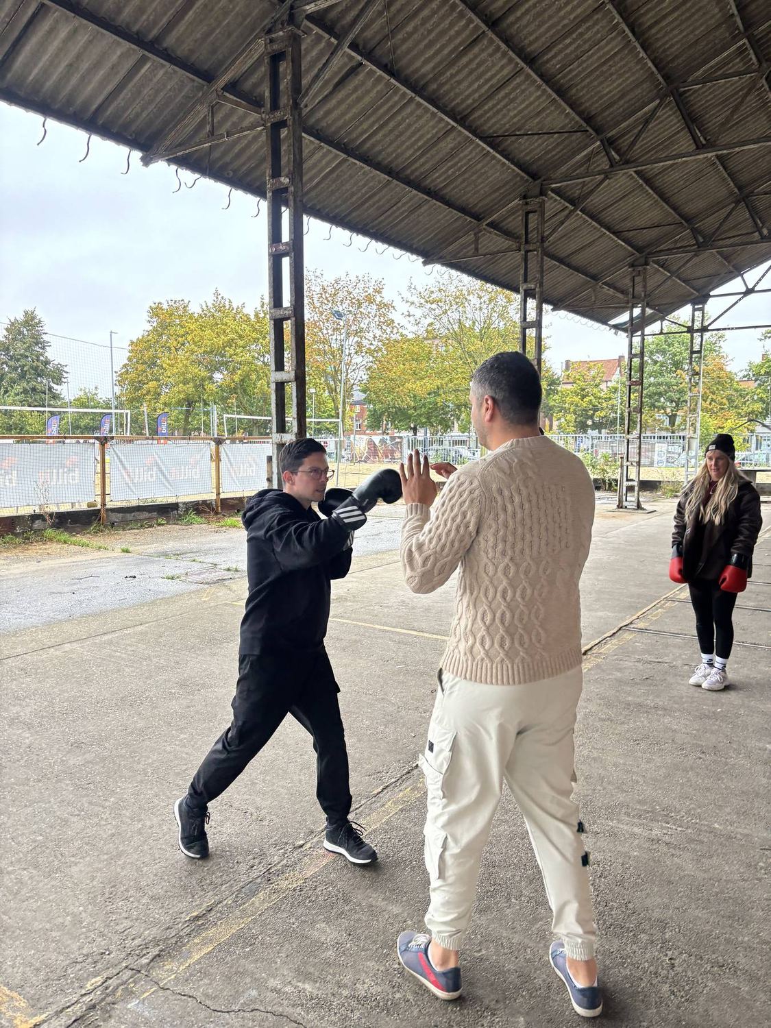 Coach vangt de stoten van een deelnemer op met zijn handen