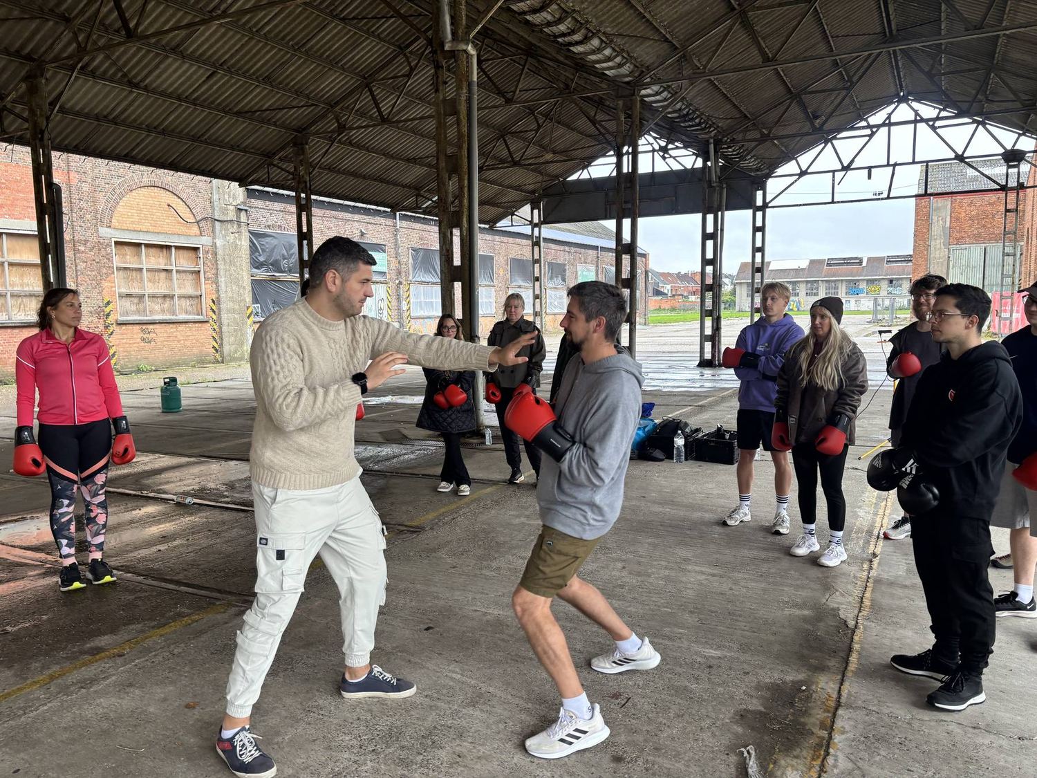 Bokstraining in Gentbrugge: de coach demonstreert een stoot terwijl de groep toekijkt